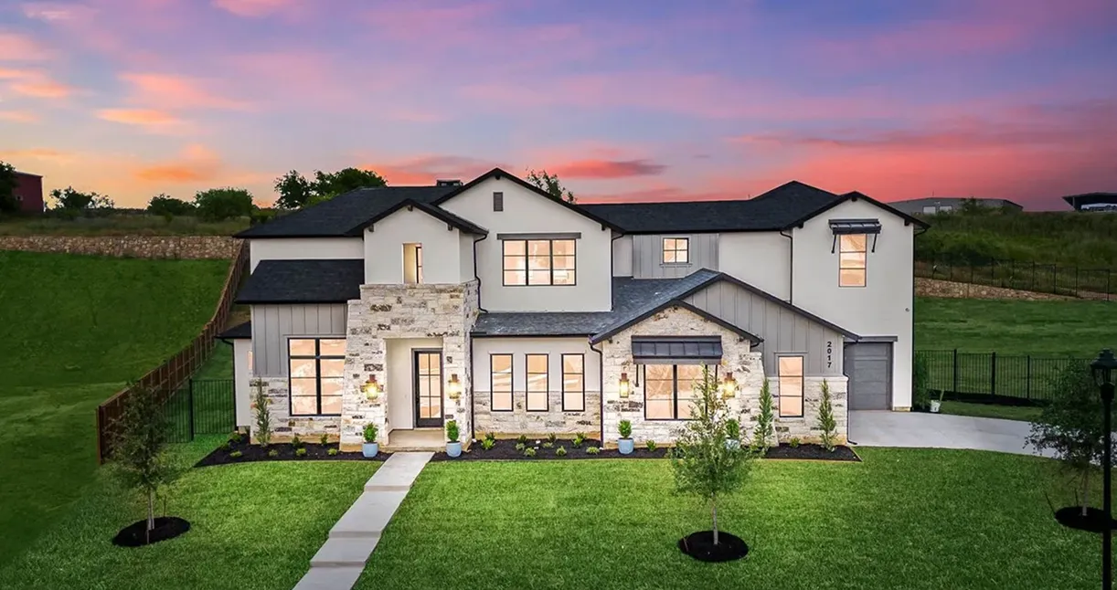 Modern house at sunset with green lawn.