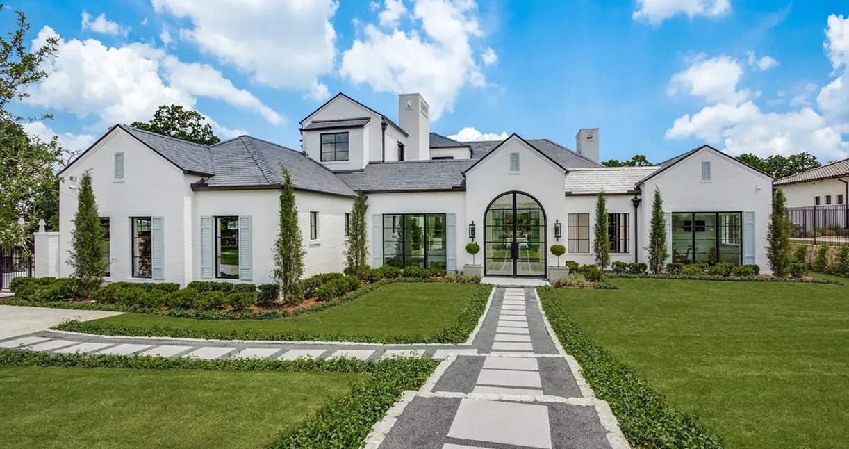 Modern white house with manicured lawn.
